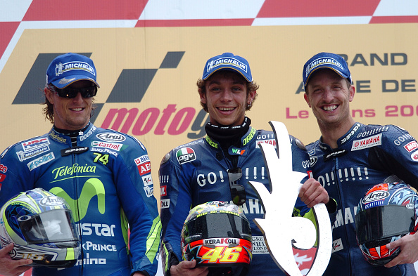Italian Valentino Rossi (L) and US Colin Edwards (R) jubilate on the podium after Rossi won the French Moto GP and Edwards finished third on May 18